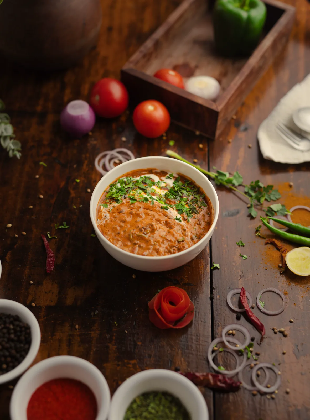 A bowl of dal makhani on a wooden table