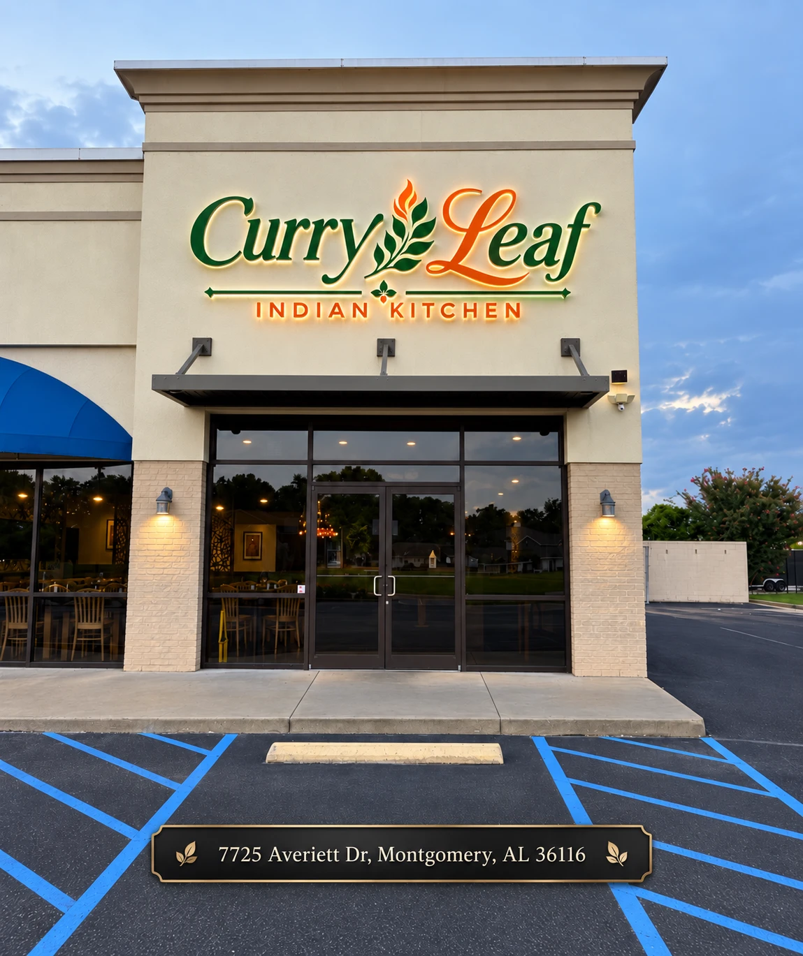 The Curry Leaf Indian Kitchen storefront at 7725 Averiett Dr in Montgomery, Alabama, lit at dusk