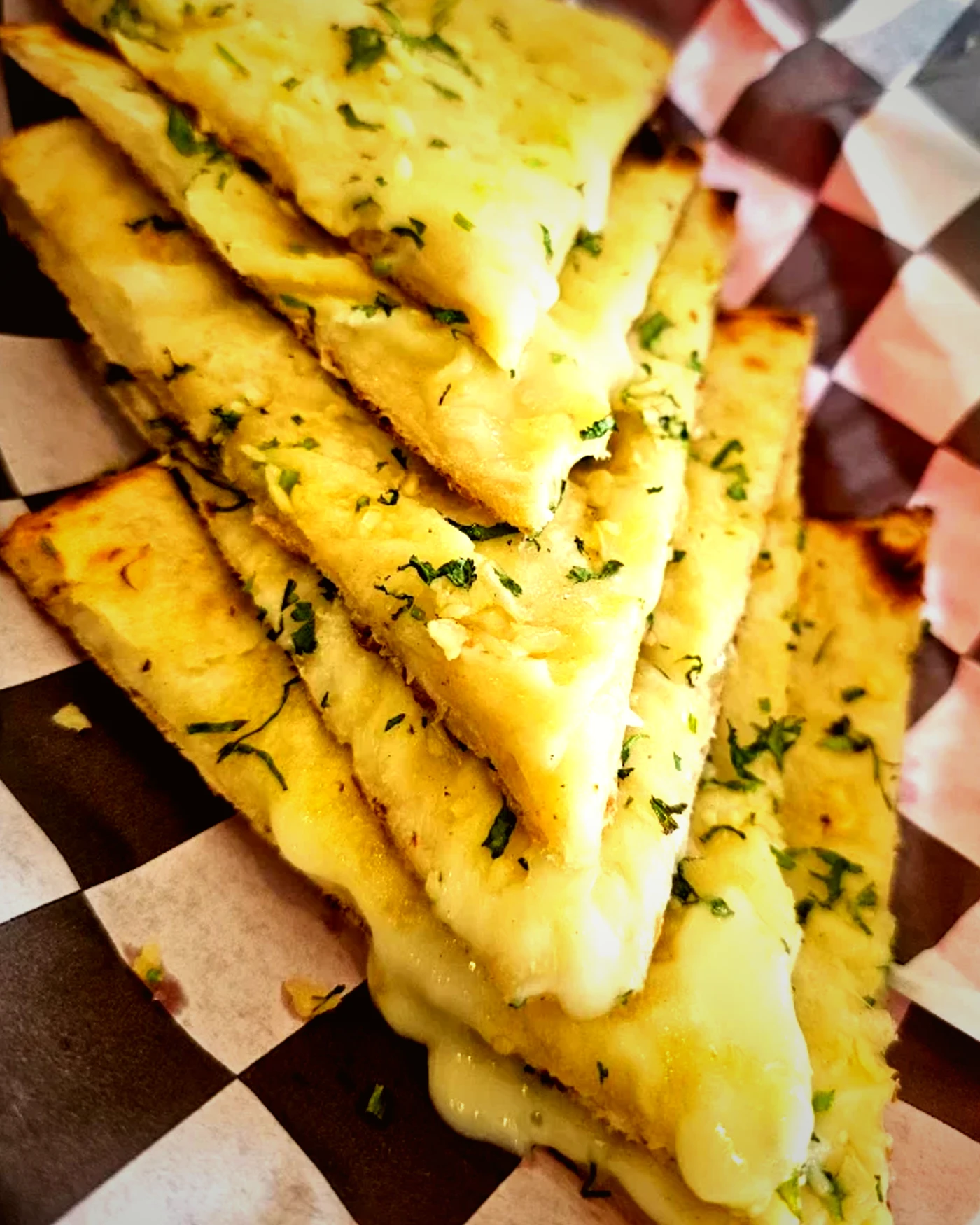 Cheese naan cut into wedges and garnished with herbs