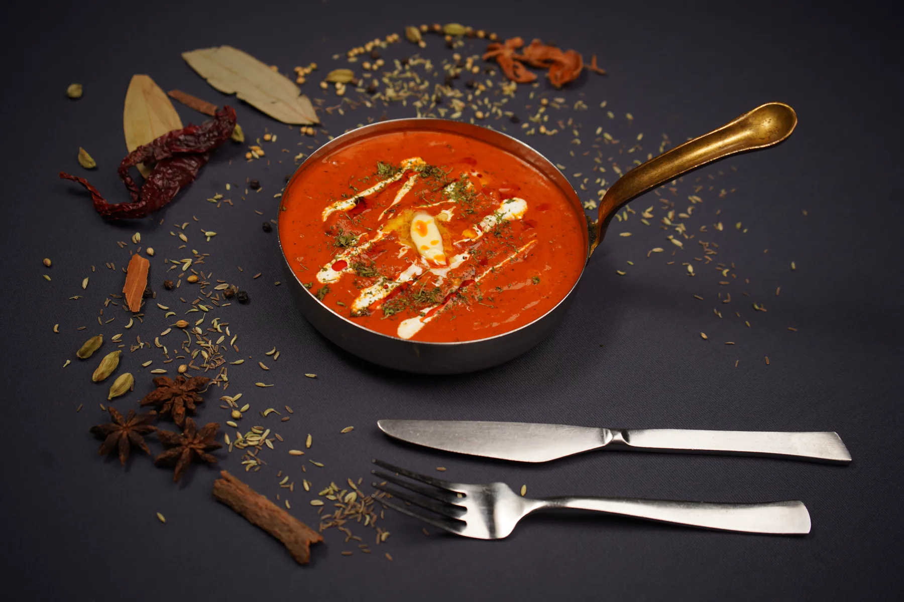 Butter chicken served in a handled pan with cream on top