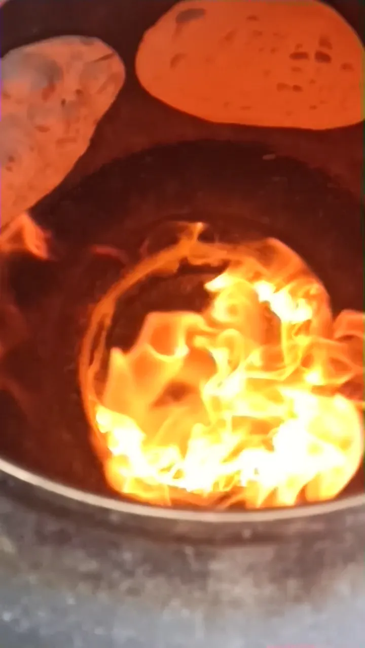 Naan baking against the wall of a tandoor